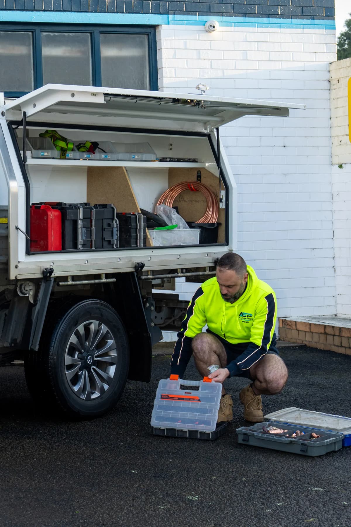 Sorting fittings beside the open ute canopy